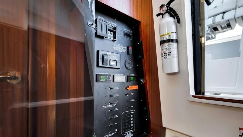 All Jack'd Up Yacht Photos Pics Electrical panel inside 2023 Pursuit S 428 Sport boat with fire extinguisher.