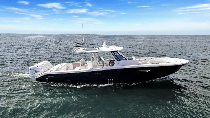 All Jack'd Up Yacht Photos Pics 2023 Pursuit S 428 Sport boat cruising on open water under a clear blue sky.