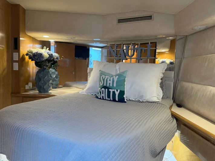Negotiator Yacht Photos Pics Bedroom interior of 1994 Hatteras 54 Convertible yacht with "Stay Salty" pillow and floral decor.