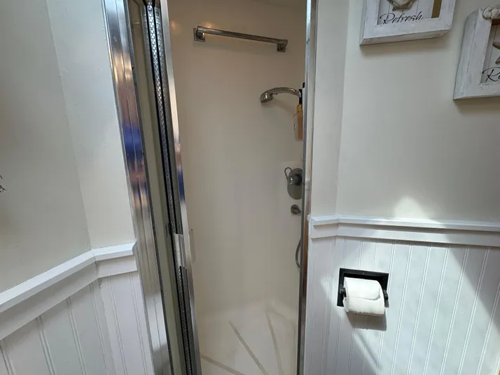 Negotiator Yacht Photos Pics Shower area in 1994 Hatteras 54 Convertible yacht bathroom, featuring chrome fixtures and white paneling.