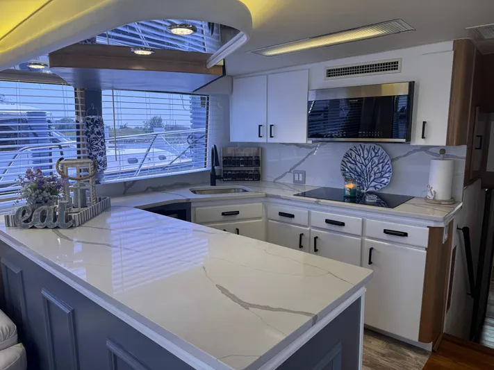Negotiator Yacht Photos Pics Luxurious kitchen interior of 1994 Hatteras 54 Convertible yacht with modern appliances and sleek design.