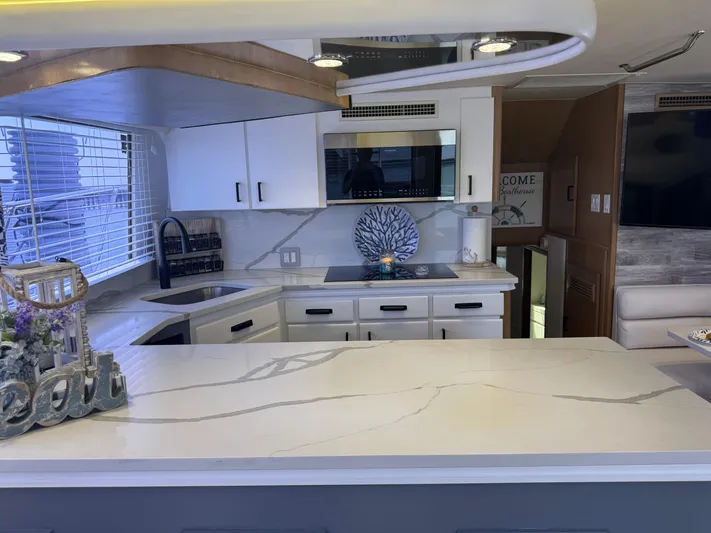 Negotiator Yacht Photos Pics Modern kitchen interior of 1994 Hatteras 54 Convertible yacht with sleek countertops and appliances.