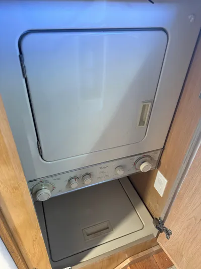 Negotiator Yacht Photos Pics Laundry unit inside 1994 Hatteras 54 Convertible yacht, featuring a compact washer and dryer.