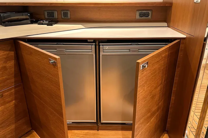 F45021 Yacht Photos Pics Wooden cabinetry with open doors revealing dual stainless steel appliances on a 2021 Princess F45 yacht.