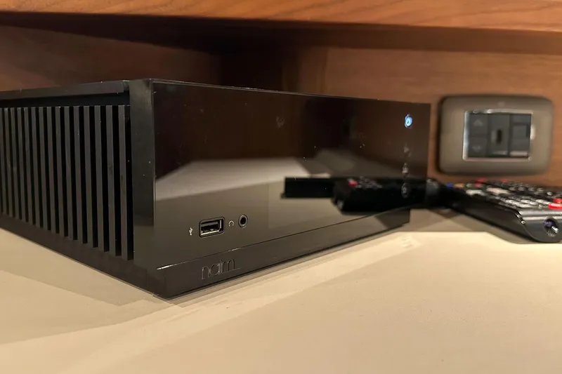 F45021 Yacht Photos Pics Black electronic device with USB port and remote, placed on a wooden shelf.