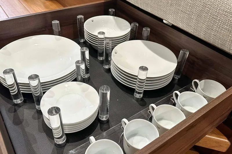 F45021 Yacht Photos Pics Organized drawer with white plates and cups on a Princess F45 yacht, 2021 model.