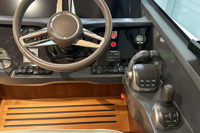 F45021 Yacht Photos Pics Steering console of a 2021 Princess F45 yacht with modern controls and wooden flooring.
