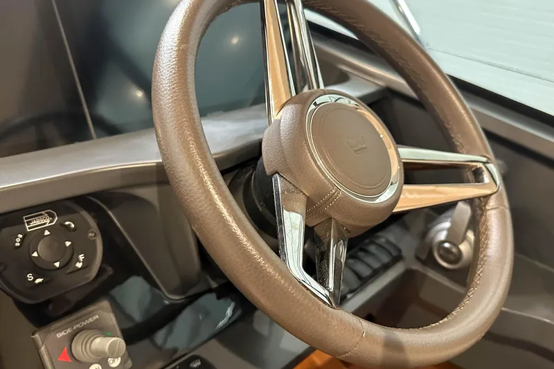F45021 Yacht Photos Pics Steering wheel of 2021 Princess F45 yacht, featuring sleek design and control panel.