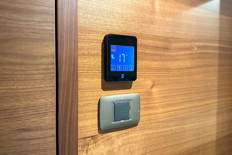 F45021 Yacht Photos Pics Digital thermostat and light switch on wooden panel, Princess F45 yacht, 2021 model.