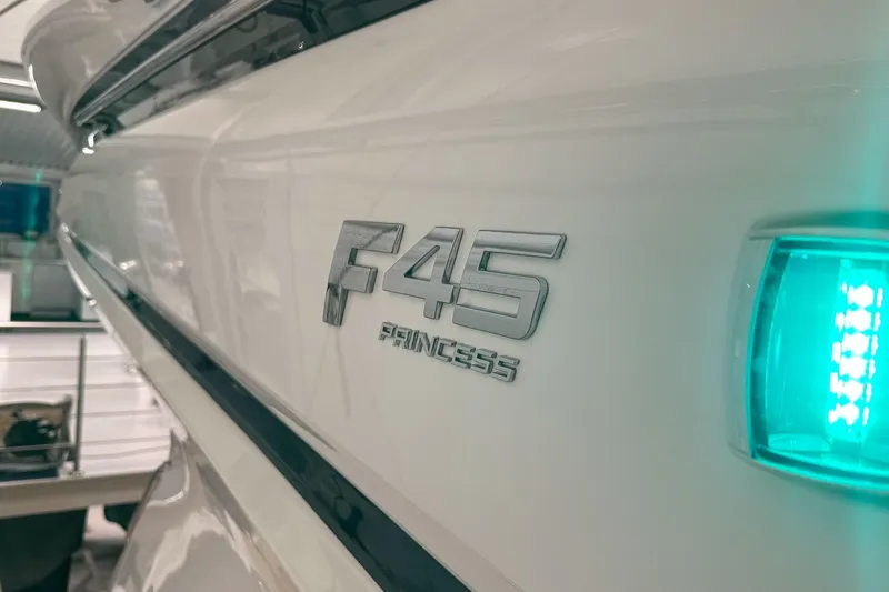 F45021 Yacht Photos Pics 2021 Princess F45 yacht with illuminated side emblem in a showroom.