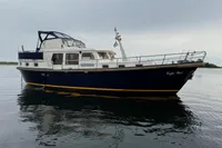 Custom Knight Craft 12,50 yacht from 2005 on calm water under cloudy sky.