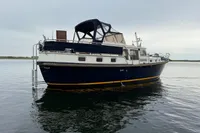 Custom Knight Craft 12,50 yacht, 2005 model, anchored on calm water under cloudy sky.