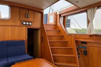 Interior of 2005 Custom Knight Craft 12,50 yacht with wooden paneling and blue seating.
