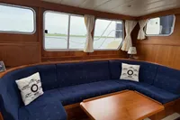 Interior of 2005 Custom Knight Craft 12,50 yacht with blue seating and wooden table.