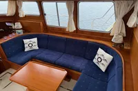 Luxurious interior of 2005 Custom Knight Craft 12,50 yacht with blue seating and wooden table.