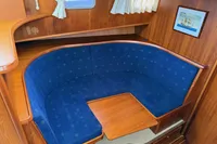 Cozy wooden boat interior with blue cushioned seating, Custom Knight Craft 12,50, 2005 model.