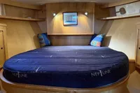 Luxurious cabin interior of 2005 Custom Knight Craft 12,50 with cozy bed and wooden finish.