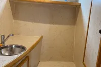 Compact bathroom in 2005 Custom Knight Craft 12,50 boat with sink, toilet, and shelf.