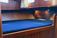Cozy wooden cabin interior of 2005 Custom Knight Craft 12,50 with blue bedding.
