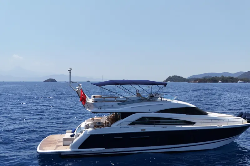  Yacht Photos Pics Luxury 2013 Fairlane Squadron yacht cruising on open sea with scenic island backdrop.