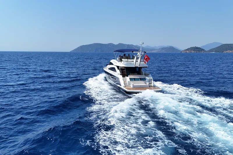  Yacht Photos Pics Luxury yacht cruising on open sea, Fairlane Squadron 2013, with scenic island backdrop.