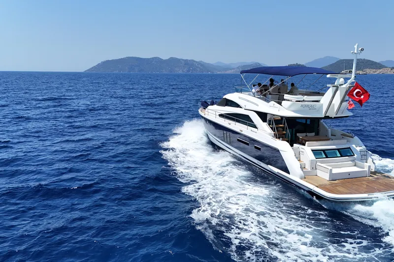  Yacht Photos Pics Luxurious 2013 Fairlane Squadron yacht cruising on blue sea with scenic island backdrop.