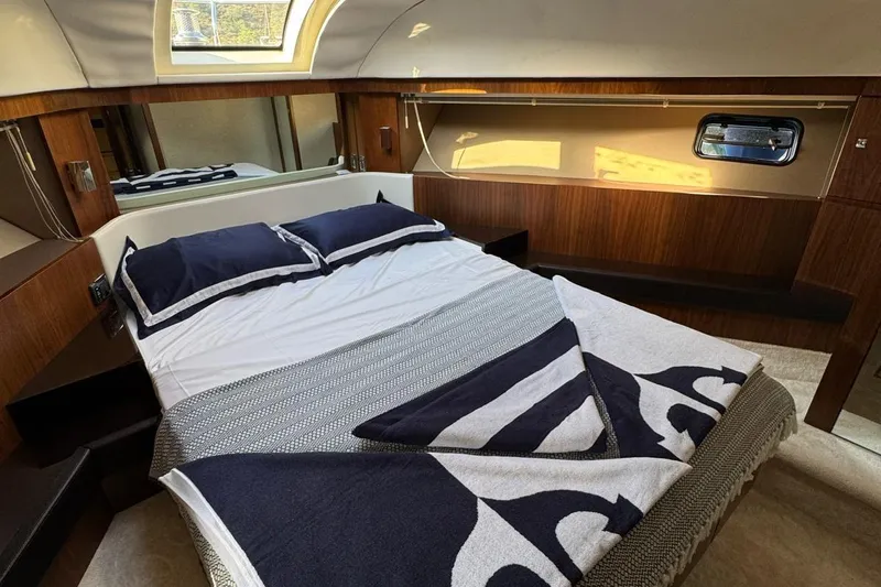  Yacht Photos Pics Luxurious cabin interior of 2013 Fairlane Squadron yacht with cozy bed and elegant wood finish.