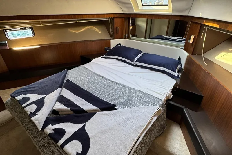  Yacht Photos Pics Luxurious cabin interior of 2013 Fairlane Squadron yacht with cozy bed and elegant wood finish.