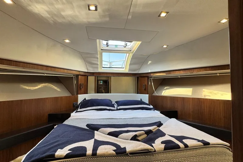  Yacht Photos Pics Luxurious cabin interior of a 2013 Fairlane Squadron yacht with a cozy bed and skylight.