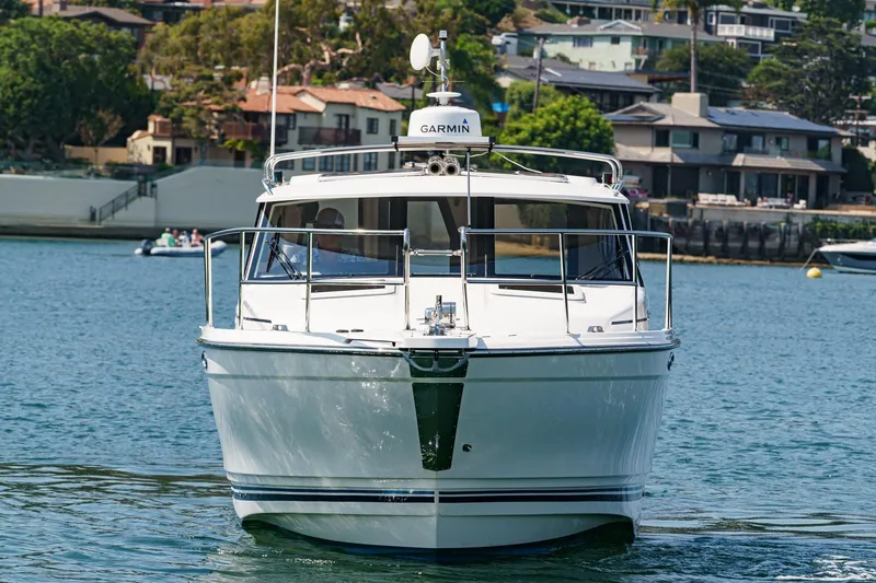 Sea Horse Yacht Photos Pics 2023 Cutwater 288 Coupe LE boat on water, with houses in the background.