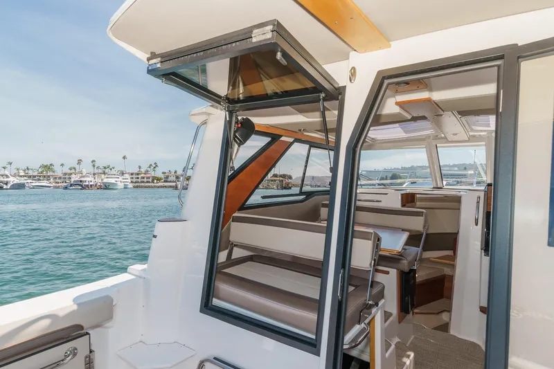 Sea Horse Yacht Photos Pics 2023 Cutwater 288 Coupe LE interior with open door, showcasing seating and ocean view.