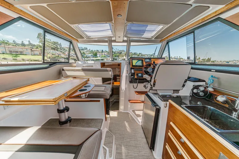 Sea Horse Yacht Photos Pics Interior of 2023 Cutwater 288 Coupe LE boat, featuring helm, seating, and kitchenette.