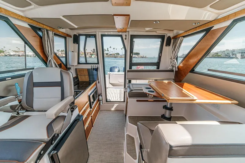 Sea Horse Yacht Photos Pics 2023 Cutwater 288 Coupe LE interior with modern seating and dining area, overlooking water.