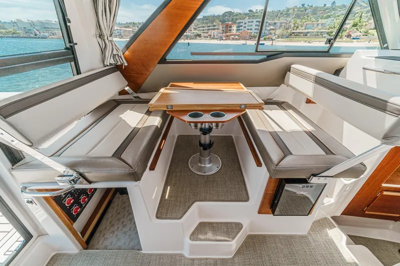 Sea Horse Yacht Photos Pics 2023 Cutwater 288 Coupe LE interior with seating and table, overlooking waterfront.
