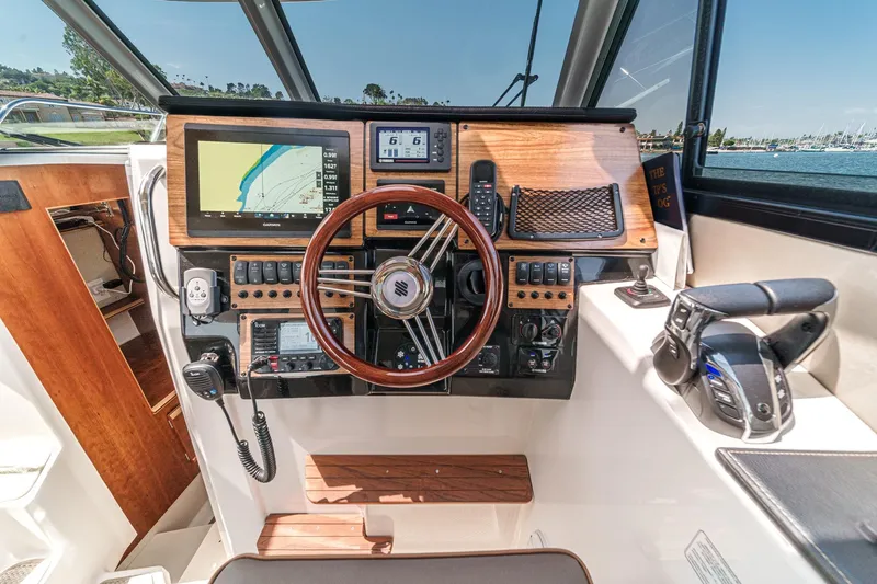 Sea Horse Yacht Photos Pics 2023 Cutwater 288 Coupe LE helm with navigation controls and wooden steering wheel.