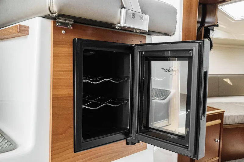 Sea Horse Yacht Photos Pics 2023 Cutwater 288 Coupe LE interior with open mini fridge and wooden cabinetry.