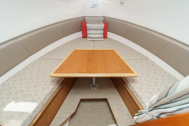 Sea Horse Yacht Photos Pics 2023 Cutwater 288 Coupe LE interior with cushioned seating and wooden table.