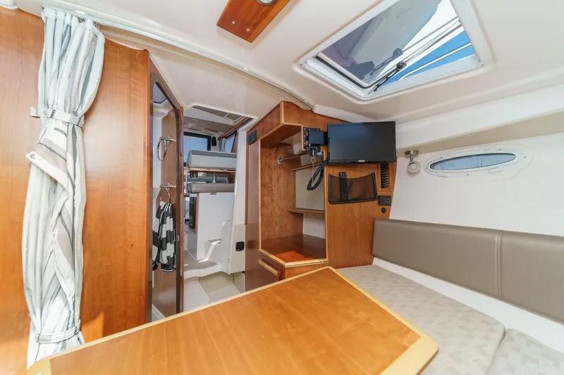 Sea Horse Yacht Photos Pics Interior of 2023 Cutwater 288 Coupe LE, featuring seating, table, and mounted TV.