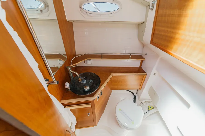 Sea Horse Yacht Photos Pics 2023 Cutwater 288 Coupe LE bathroom with wooden cabinetry and modern sink design.