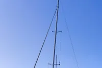 Sailboat Dragonfly 920, 2002 model, docked by a scenic lakeside under clear blue sky.