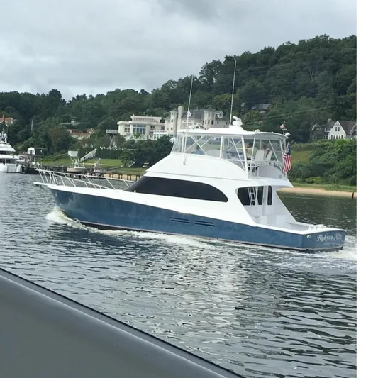 Ala-ash Yacht Photos Pics 2003 Post Flybridge Convertible yacht cruising on a calm river near a wooded shoreline.
