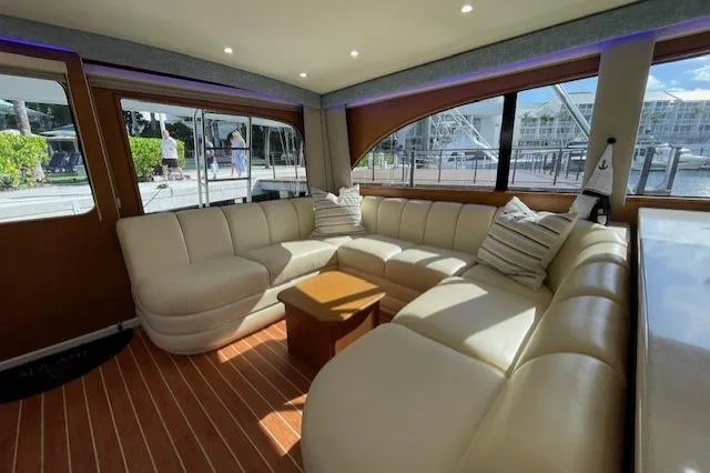Ala-ash Yacht Photos Pics Luxurious interior of a 2003 Post Flybridge Convertible yacht with plush seating and wooden flooring.
