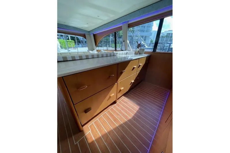 Ala-ash Yacht Photos Pics Interior of 2003 Post Flybridge Convertible yacht with wooden cabinetry and striped flooring.