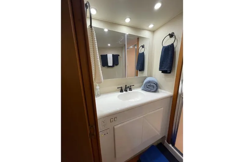 Ala-ash Yacht Photos Pics Bathroom interior of 2003 Post Flybridge Convertible yacht with modern fixtures and blue towels.