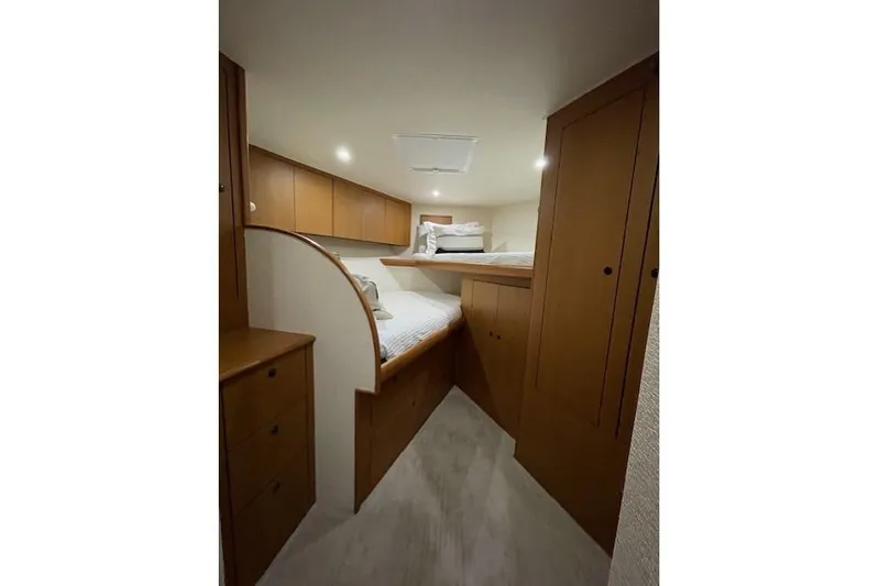 Ala-ash Yacht Photos Pics 2003 Post Flybridge Convertible cabin with wooden cabinetry and cozy bedding.