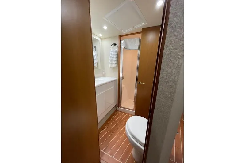Ala-ash Yacht Photos Pics Bathroom interior of 2003 Post Flybridge Convertible yacht with shower and wooden flooring.