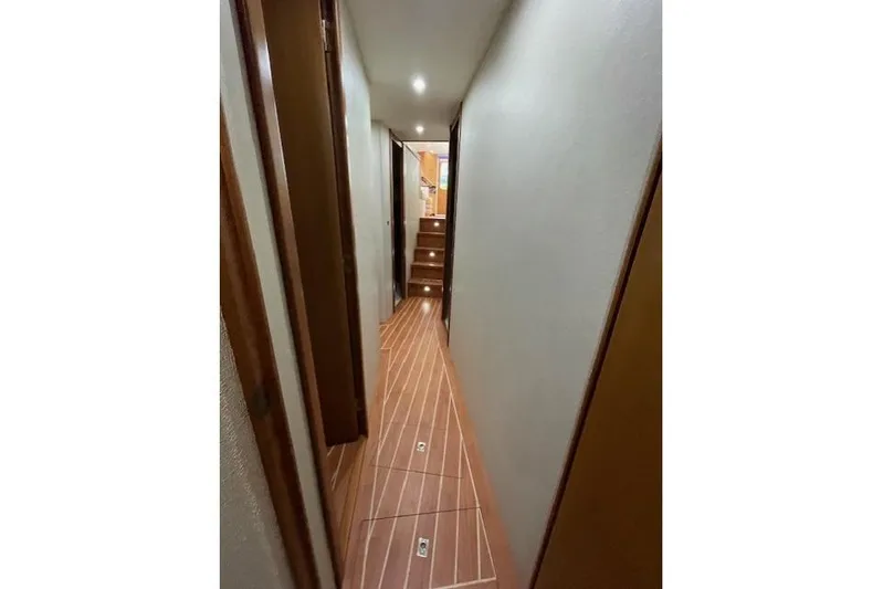 Ala-ash Yacht Photos Pics Narrow hallway inside 2003 Post Flybridge Convertible yacht with wooden flooring and stairs.