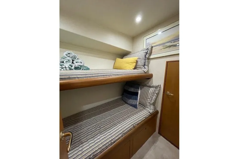 Ala-ash Yacht Photos Pics Bunk beds in 2003 Post Flybridge Convertible yacht cabin with striped bedding and decorative pillows.