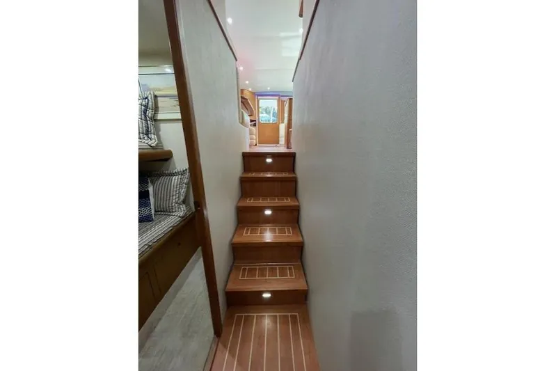 Ala-ash Yacht Photos Pics Interior stairs of 2003 Post Flybridge Convertible yacht with wooden finish and lighting.