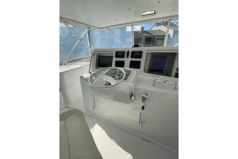 Ala-ash Yacht Photos Pics 2003 Post Flybridge Convertible yacht helm with modern navigation equipment and steering wheel.